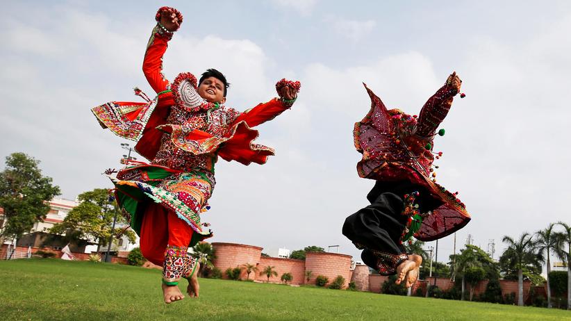 "Fremdheit": Darsteller in traditioneller Kleidung proben einen Volkstanz für das hinduistische Fest Navratri in Indien.