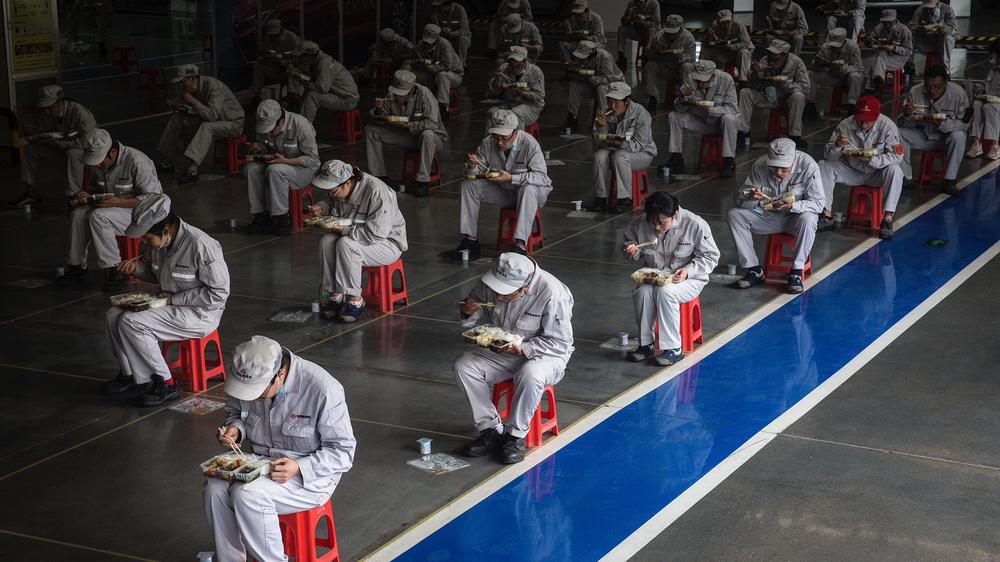 China: Fabrikarbeiter in Wuhan halten während ihrer Mittagspause zwei Meter Abstand.