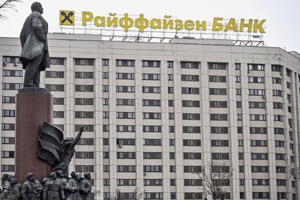 Raiffeisenbank in Russland: Das Logo der Raiffeisen Bank auf einem Gebäude in Moskau im April 2023. Im Vordergrund eine Statue des Gründers der Sowjetunion Wladimir Iljitsch Lenin.