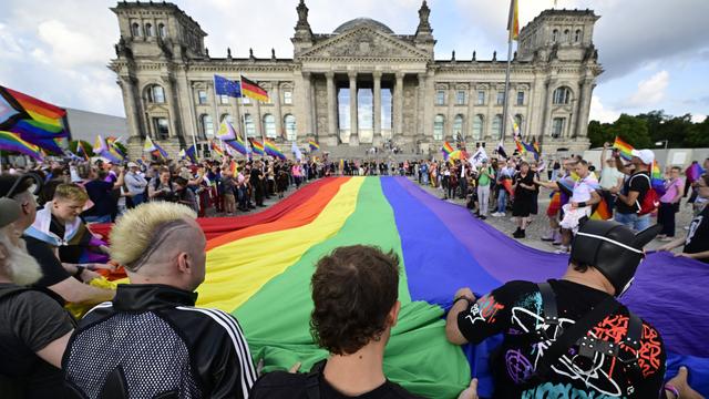 Christopher Street Day: Aktivisten rollen riesige Regenbogenflagge vor Reichstagsgebäude aus