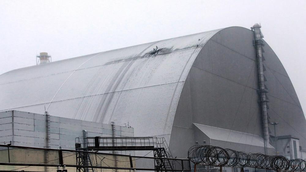 Die Überreste des 1986 havarierten Reaktors des Atomkraftwerks Tschernobyl werden inzwischen von einem Stahlbogen geschützt. Deutlich ist der Schaden zu erkennen.