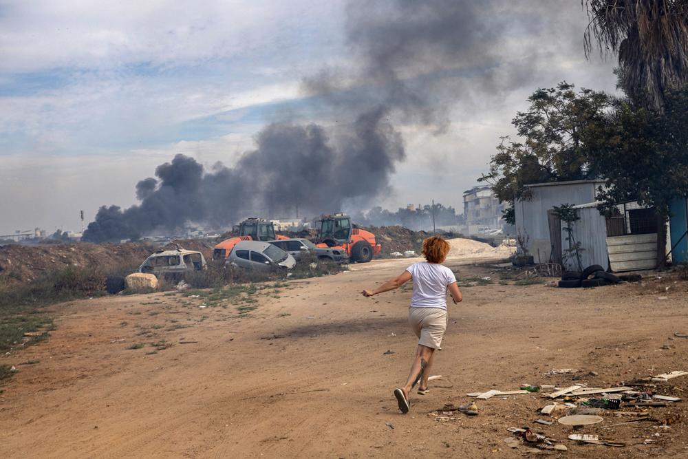 Nahostkonflikt: 7. Oktober 2023: Eine Frau in Aschkelon bringt sich vor Raketen der Hamas in Sicherheit.