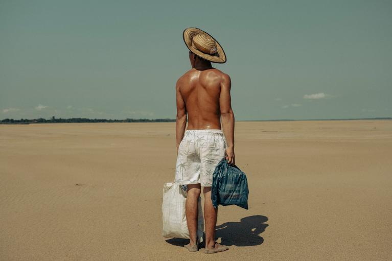  Im Flussbett des Solimões bringt ein junger Mann Lebensmittel ins Dorf Manacapuru, in dem seine Mutter lebt. Normalerweise ist das Dorf per Boot erreichbar, während der schweren Dürre im Amazonasgebiet 2024 aber nur zu Fuß.