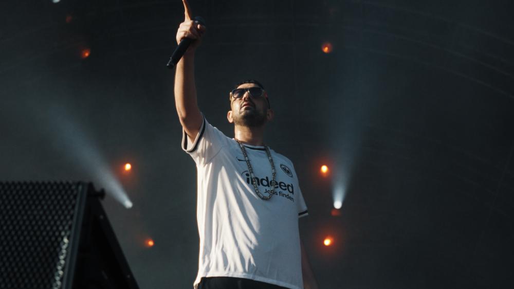  Szene aus der Dokumentation "Babo – Die Haftbefehl-Story", die ab 28. Oktober auf Netflix läuft. Zu sehen ist Haftbefehl hier im Jahr 2023 bei einem Konzert in Frankfurt.