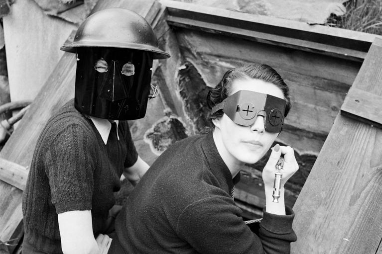Durchhalten: "Keep calm and carry on" – Ruhe bewahren und weitermachen: zwei Frauen mit sogenannten Feuermasken, die gegen Brandbomben schützen sollten, in London 1941, aufgenommen von der berühmten Fotografin Lee Miller.
