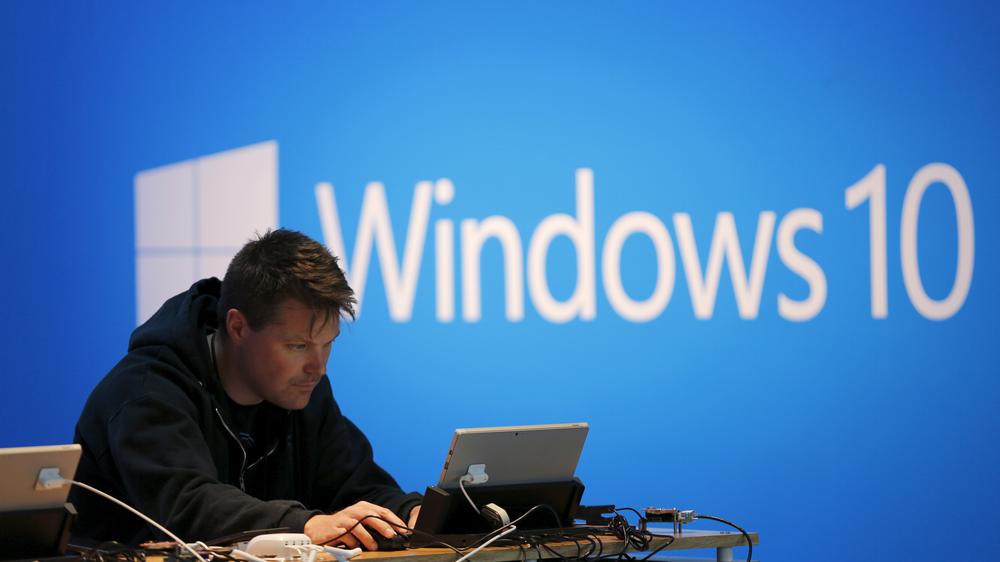 Ein Mann am Laptop vor einem Display mit Windows 10 in San Francisco