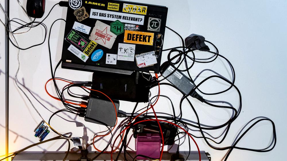 Chaos Communication Congress: Mit Stickern beklebter Laptop und Kabel auf einem Tisch