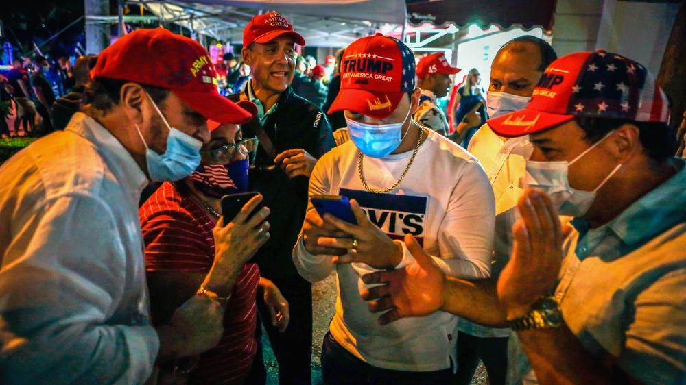 Social Media: Gebannt am Smartphone: Unterstützter des amtierenden US-Präsidenten Donald Trump verfolgen in Miami in Florida die Nachrichten zur Wahl.