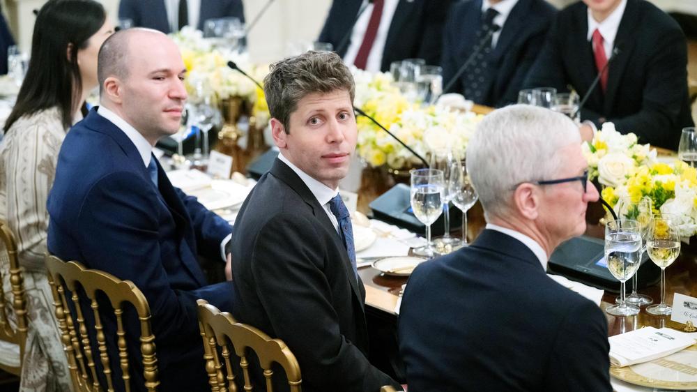 Apple verklagt OpenAI: Sam Altman, CEO von OpenAI, sitzt neben Tim Cook, dem CEO von Apple, beim Abendessen im Weißen Haus.