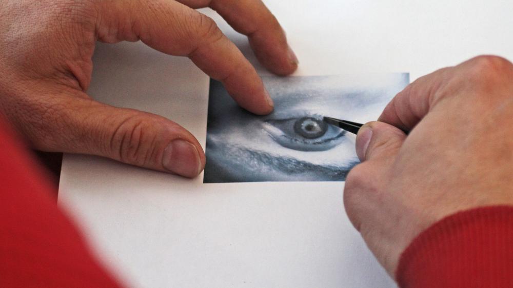Biometrie: Jan Krissler legt eine Kontaktlinse auf ein Foto seines Auges, um einen Irisscanner zu täuschen.