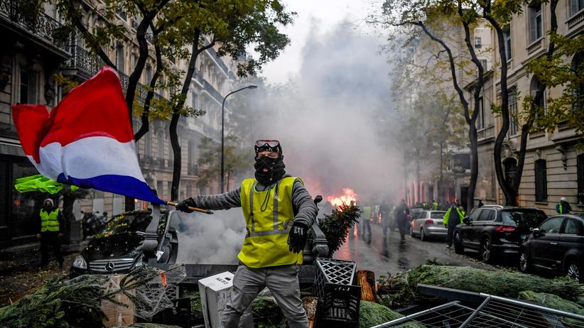 Gelbwesten: Ausschreitungen im Advent, brennende Barrikaden in Paris: ein Anhänger der Gelbwesten inmitten der eskalierenden Proteste