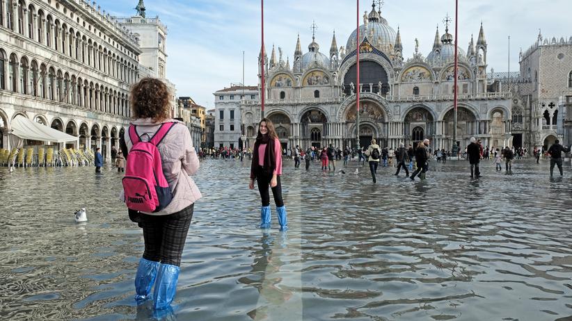 Venedig unter Wasser: Samstag, 16. November in Venedig: Touristen posieren auf dem überschwemmten Markusplatz.