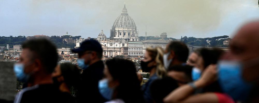 People gather at a high point overlooking Saint-Peter Basilica to see the Italian Air Force aerobatic unit Frecce Tricolori (Tricolor Arrows) flying over Rome to mark Republic Day on June 2, 2021. (Photo by Filippo MONTEFORTE / AFP) (Photo by FILIPPO MONTEFORTE/AFP via Getty Images)