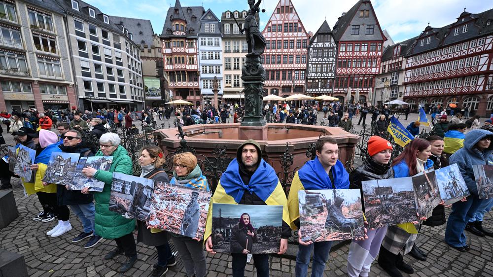 Demonstrationen in Deutschland: Demonstranten halten Kriegsbilder in der Hand, als sie am 24. Februar 2024 in Frankfurt an einer Kundgebung zur Unterstützung der Ukraine anlässlich des zweiten Jahres der russischen Militärinvasion in der Ukraine teilnehmen. 