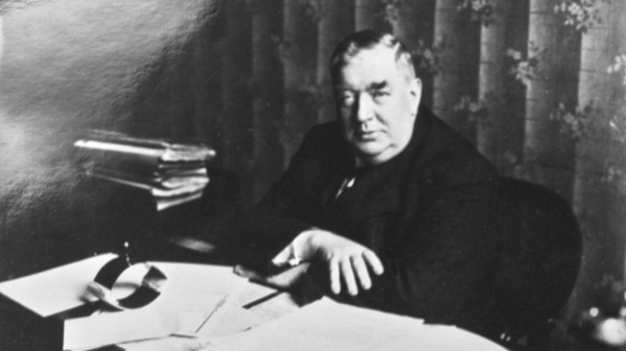 "Verbrechen"-Podcast: Mordkommissar Ernst Gennat revolutionierte die Kriminalistik, hier an seinem Schreibtisch in der Berliner Mordkommission. Ernst Gennat, der Buddha vom Alexanderplatz, war eine Autoritätsperson. Ihm ist es zu verdanken, dass sich die Mordaufklärungsquote seit seiner Zeit verdoppelt hat (92,4%). Satte 150 Kilo schwer, eine Mischung aus Sanftmut und Hartnäckigkeit, war er Vorreiter der modernen Kriminalistik. Spurensicherung, ständige Mordkommissionen, Profiling. Täterkarte...alles begann am 30. Mai 1905 als Gennat seine Prüfung zum Kriminalbeamten ablegte.