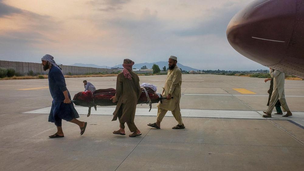 Afghanistan: Menschen in Dschalalabad tragen eine verletzte Person zu einem Krankenwagen: Nach einem Erdbeben der Stärke 6,0 im Osten Afghanistans gibt es zahlreiche Tote und Verletzte.