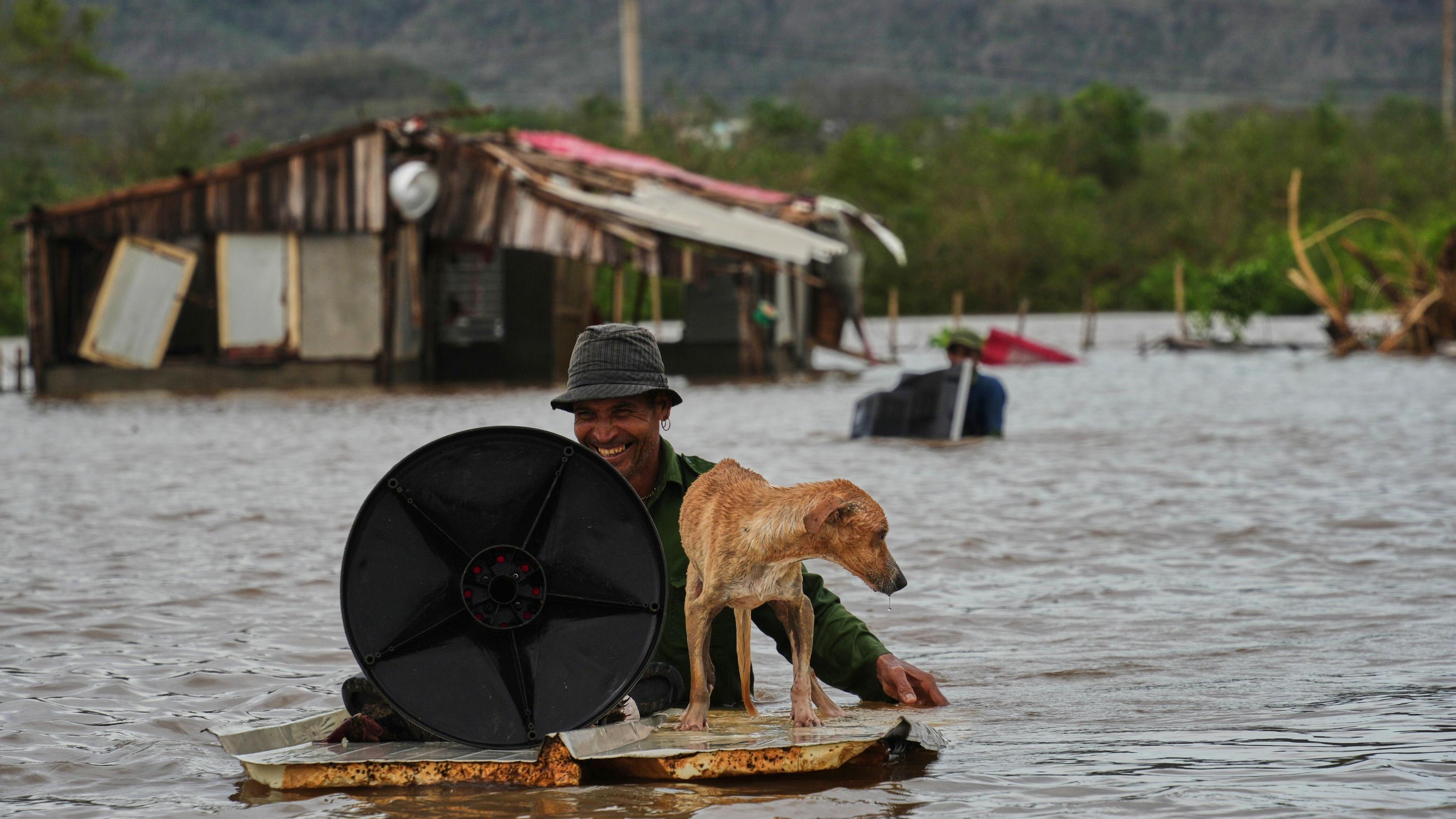 Tropischer Wirbelsturm: Ein Mann rettet seinen Hund und seine Habseligkeiten aus seinem zerstörten Haus.