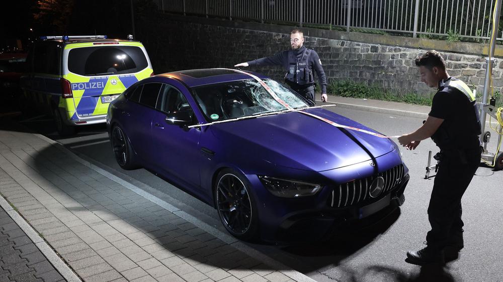 Remscheid: Der beschädigte Mercedes des Angeklagten steht nach dem Unfall auf einer Straße in Remscheid-Lennep. Polizeibeamte sichern Spuren am Fahrzeug.
