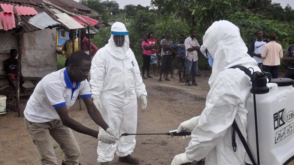 Liberia : Mitarbeiter im Gesundheitswesen desinfizieren ihre Hände, nachdem sie Kontakt mit Ebola-Patienten hatten. 