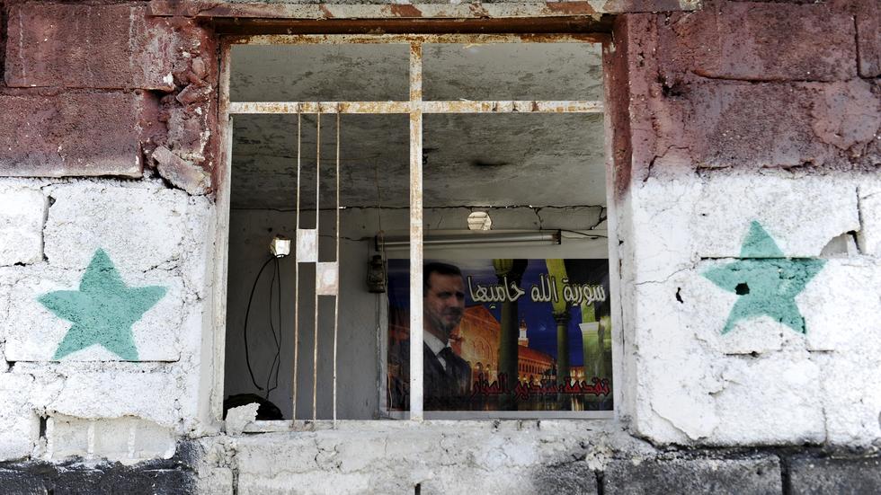 Ein Radfahrer fährt an zerstörten Gebäuden in Homs entlang.