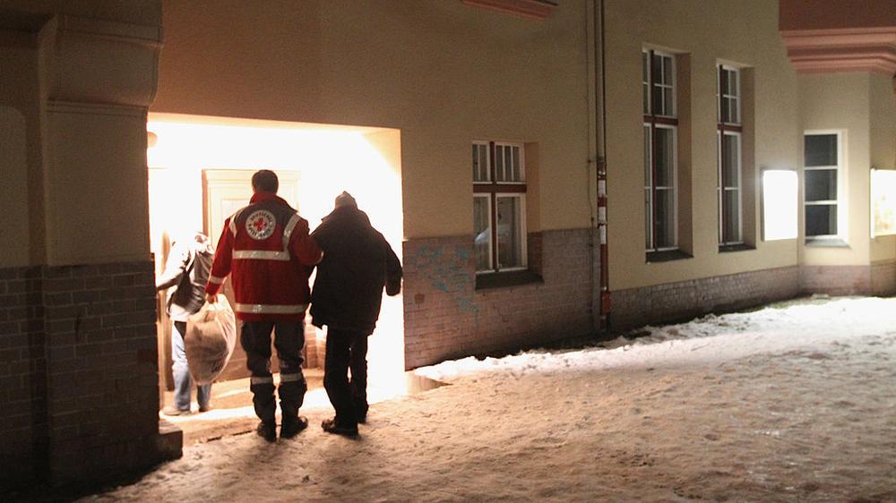 Obdachlose im Winter: Ein Helfer des Roten Kreuzes bringt in Berlin einen Obdachlosen in eine wärmende Unterkunft.