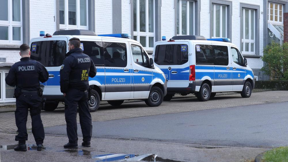 Großeinsatz: In Solingen stehen Polizeibeamte in der Nähe eines Gebäudes, das durchsucht wird.