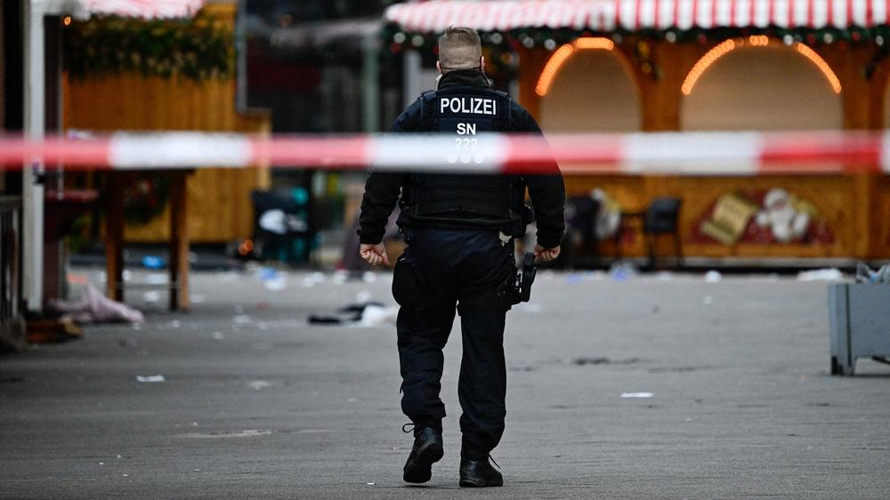 Straftaten: Ein Polizist geht nach dem Anschlag im vergangenen Dezember über den abgesperrten Weihnachtsmarkt in Magdeburg.