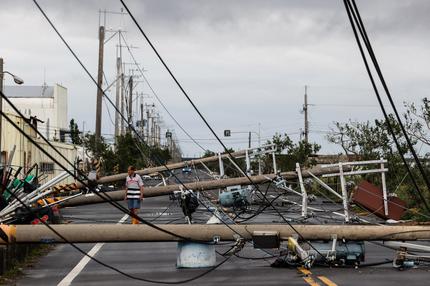 Taifun "Danas": A man walks among utility poles knocked down during Typhoon Danas in Tainan on July 7, 2025. Typhoon Danas made landfall on the west coast of Taiwan late on July 6, the Central Weather Administration said, dumping torrential rain on the island that triggered flooding and landslides.