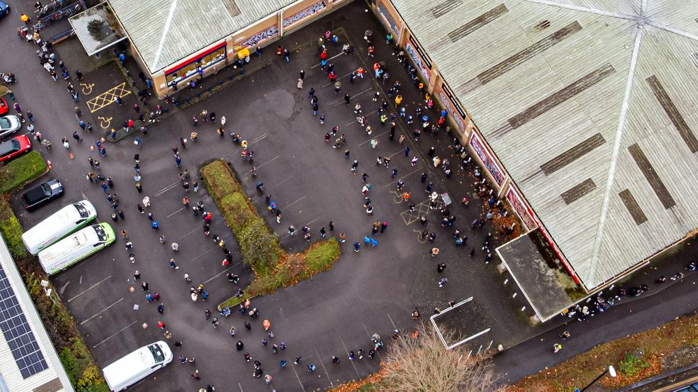 Corona-Herbst: Menschen stehen Schlange vor einem britischen Impfzentrum, aufgenommen im Dezember 2021.