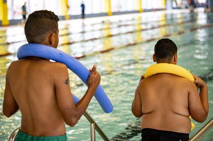 Lancet-Kommission: Übergewicht schon in jungen Jahren: Zwei Jugendliche stehen am Beckenrand eines Schwimmbads.