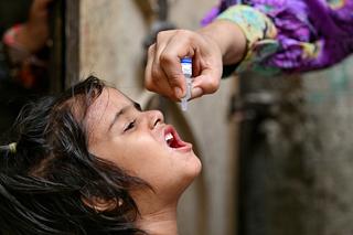 Impfungen: A health worker administers polio drops to a child for vaccination on the first day of a nationwide week-long poliovirus eradication campaign in Karachi on May 26, 2025. (Photo by Asif HASSAN / AFP) (Photo by ASIF HASSAN/AFP via Getty Images)