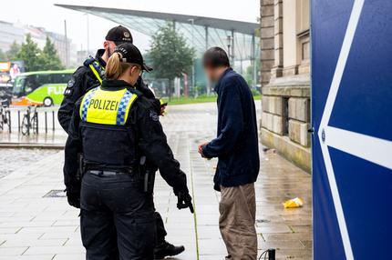 Polizisten kontrollieren auf einem Vorplatz vom Hauptbahnhof einen Mann, der mit Drogen angetroffen wurde. 