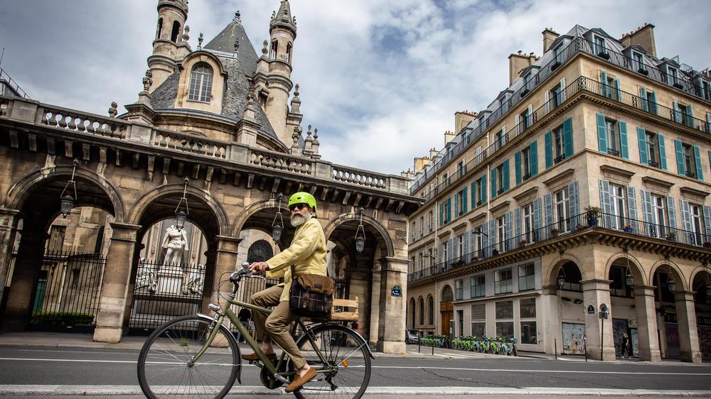 Ein Radfahrer fährt über die Straße Rue de Rivoli in Paris.