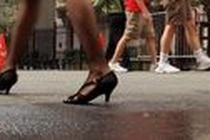 Eine Frau läuft an der New Yorker Wall Street entlang