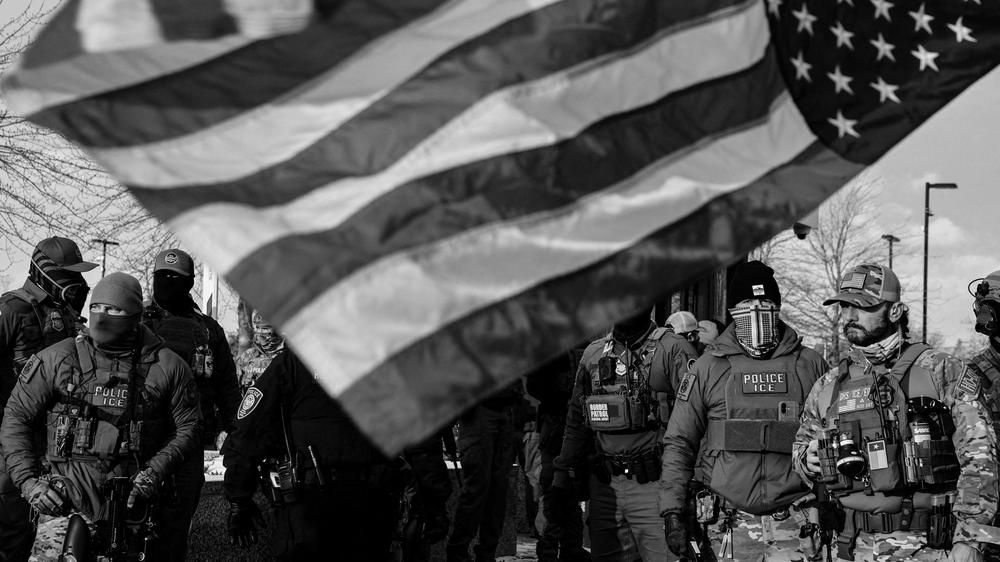 Alex S. Vitale: A protester holds an upside-down U.S. flag next to Immigration and Customs Enforcement (ICE) agents standing guard outside the Bishop Henry Whipple Federal Building during a demonstration against increased immigration enforcement, days after a U.S. Immigration and Customs Enforcement (ICE) agent fatally shot Renee Nicole Good, in Minneapolis, Minnesota, U.S., January 10, 2026. REUTERS/Tyrone Siu     TPX IMAGES OF THE DAY