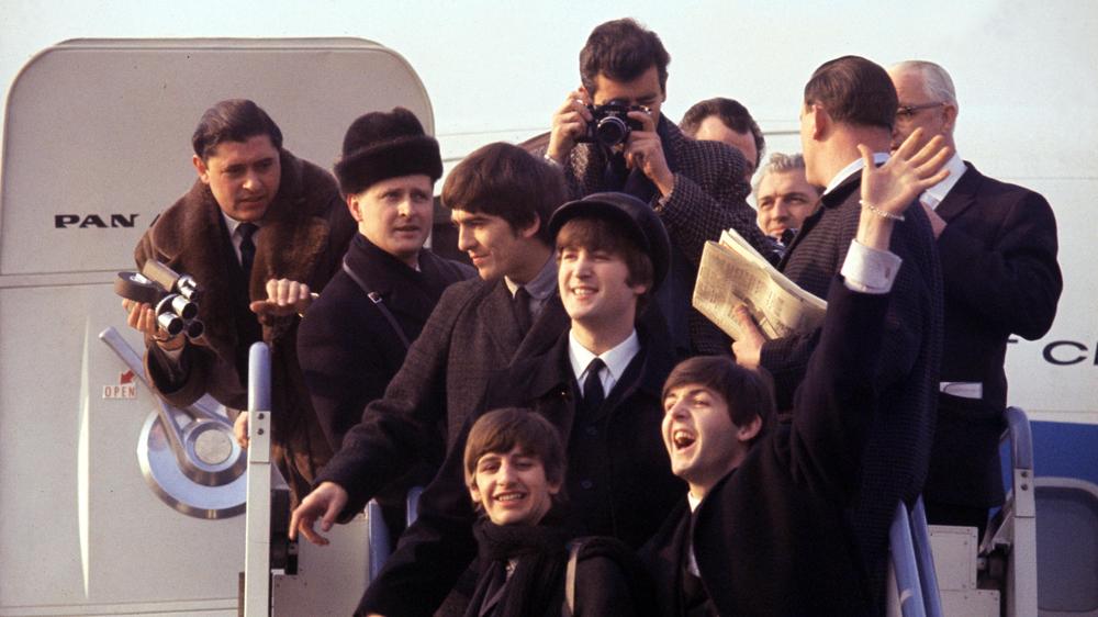  Die Beatles und ihre Entourage erreichen im Februar 1964 erstmals die USA.