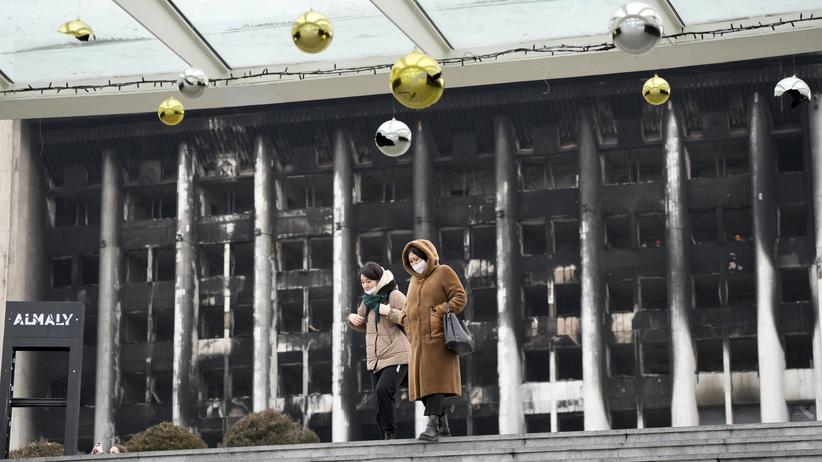 Kasachstan: Zwei Frauen vor dem ausgebrannten Rathausgebäude in Almaty