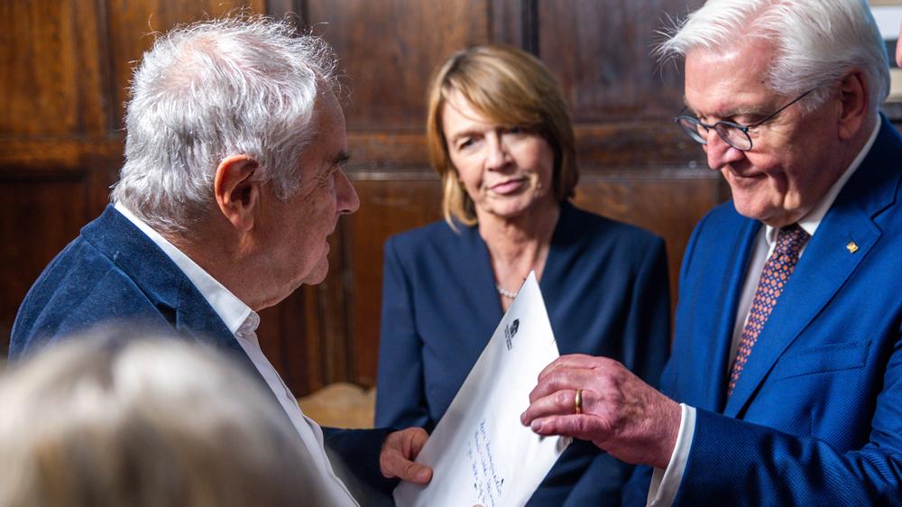  Bundespräsident Frank-Walter Steinmeier (rechts) und dessen Ehefrau Elke Büdenbender (Mitte) sprechen vor dem Festakt in Lübeck zu Ehren Thomas Manns mit dessen Enkel Frido Mann (links).