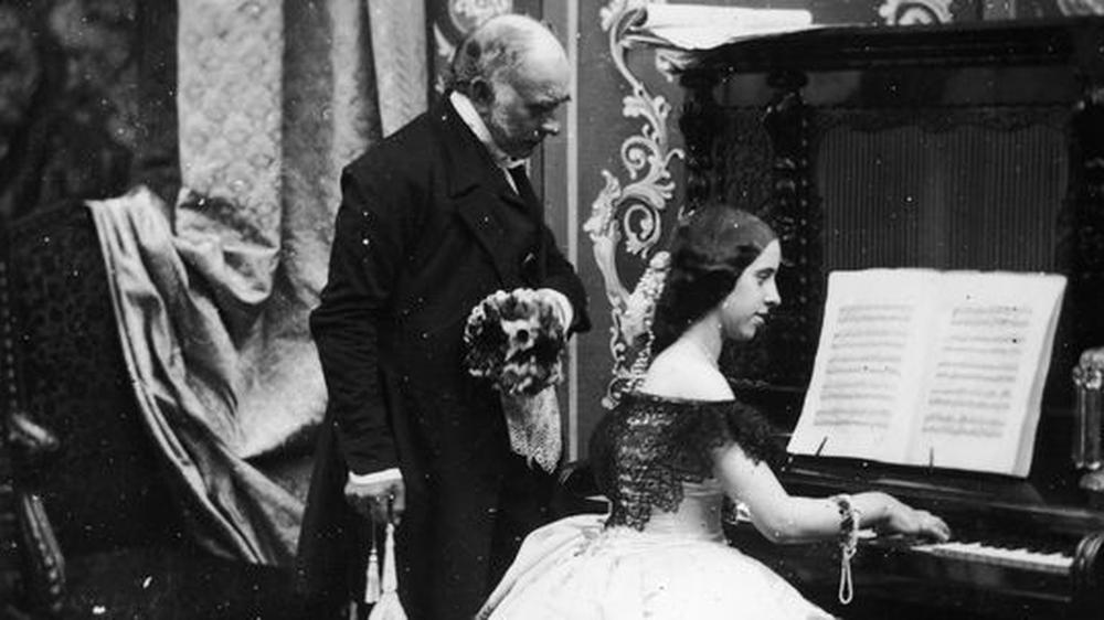 Gender-Forschung: So war's recht um 1885: Der Herr hat ein Auge drauf, dass die junge Dame sich beim Klavierspiel nicht unziemlich bewegt