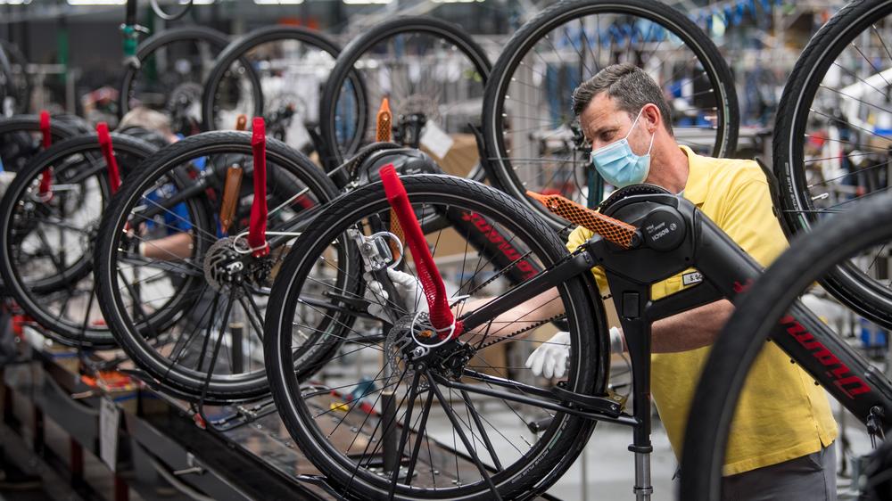 Radfahren: Ein Mitarbeiter misst die Speichenspannung von Trekking-Elektrofahrrädern im Werk des Fahrradherstellers Diamant.