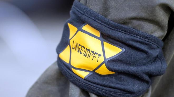 Extremismus: Bei Protesten gegen die Coronamaßnahmen trägt ein Mann einen gelben Stern mit Aufschrift «Ungeimpft».