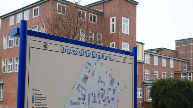 Gesundheit: Ein Lageplan steht vor einem Gebäude des Universitätsklinikums in Magdeburg.