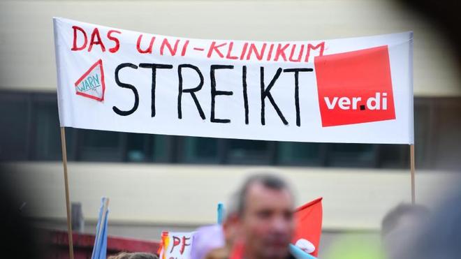 Tarife: Streikende Beschäftigte halten ein Transparent mit der Aufschrift «Das Uni-Klinikum streikt» hoch.