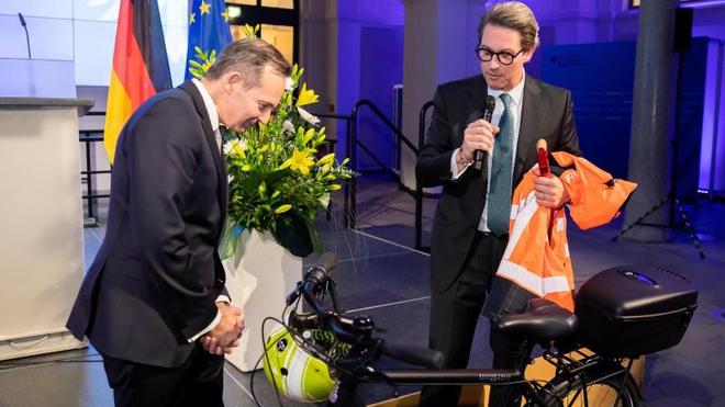 Mobilitätswende: Volker Wissing (FDP, l), Bundesminister für Verkehr und Digitales, nimmt von Andreas Scheuer (CSU), scheidender Bundesminister für Verkehr und digitale Infrastruktur, bei der Amtsübergabe im Bundesministerium für Verkehr und Digitales einen Fahrradhelm und weitere Ausrüstung entgegen.