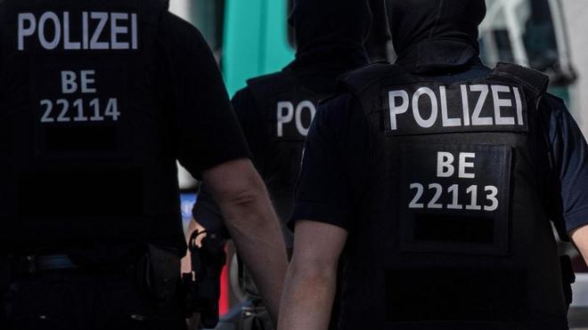 Polizei: Berliner Polizisten gehen über eine Straße.