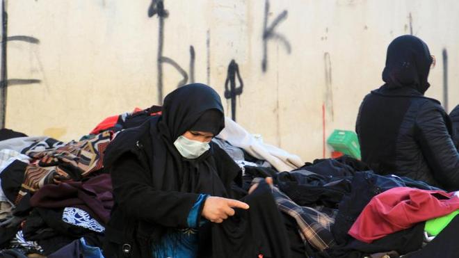 Minderwertige Altkleider: Eine Kundin schaut sich gebrauchte Kleidungsstücke auf einem zentralen Markt in Tunesiens Hauptstadt an.
