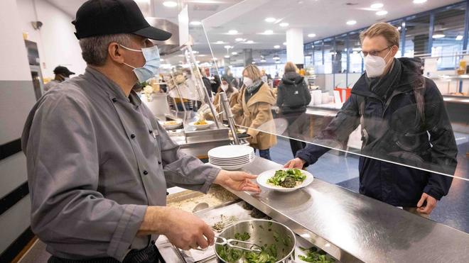 Ernährung: Ein Mitarbeiter der neuen Mensa auf dem Campus Von-Melle-Park der Uni Hamburg gibt einen Teller aus.