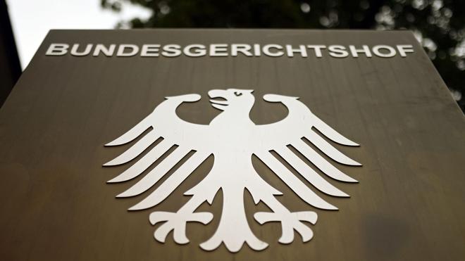Extremismus: Ein Hinweisschild mit dem Bundesadler steht vor dem Bundesgerichtshof (BGH) in Karlsruhe.