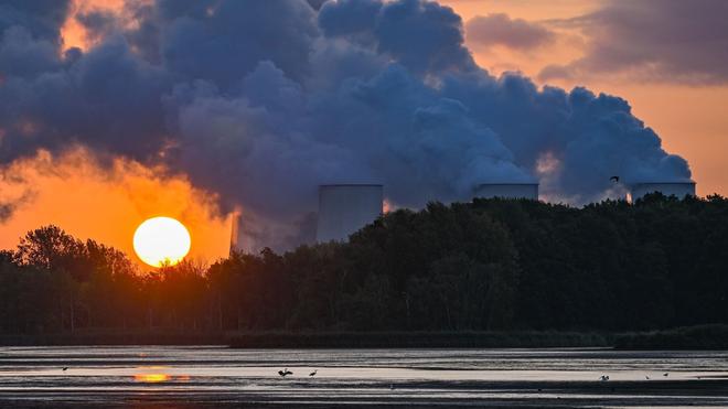 Wasser : Der Sonnenaufgang scheint hinter dampfenden Kühltürmen des Braunkohlekraftwerks Jänschwalde der Lausitz Energie Bergbau AG (LEAG).