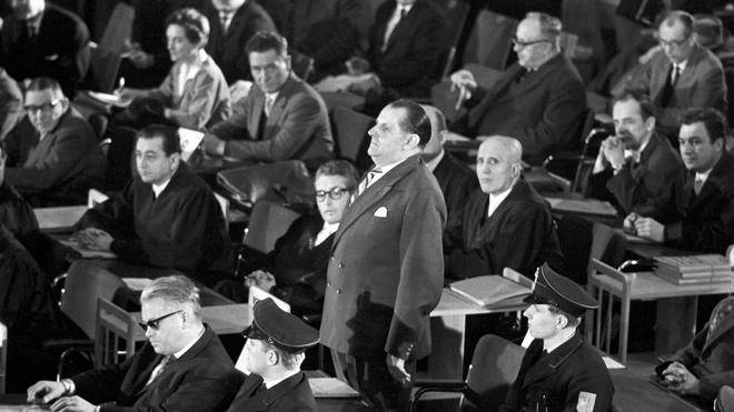 Nationalsozialismus: Der erste Auschwitz-Prozess im Plenarsaal der Frankfurter Stadtverordnetenversammlung wird eröffnet. In der ersten Reihe sitzt der Angeklagte Victor Capesius (mit dunkler Brille), hinter ihm steht der Angeklagte Oswald Kaduk. (zu dpa: «Als die Täter von Auschwitz in Frankfurt vor Gericht kamen»)